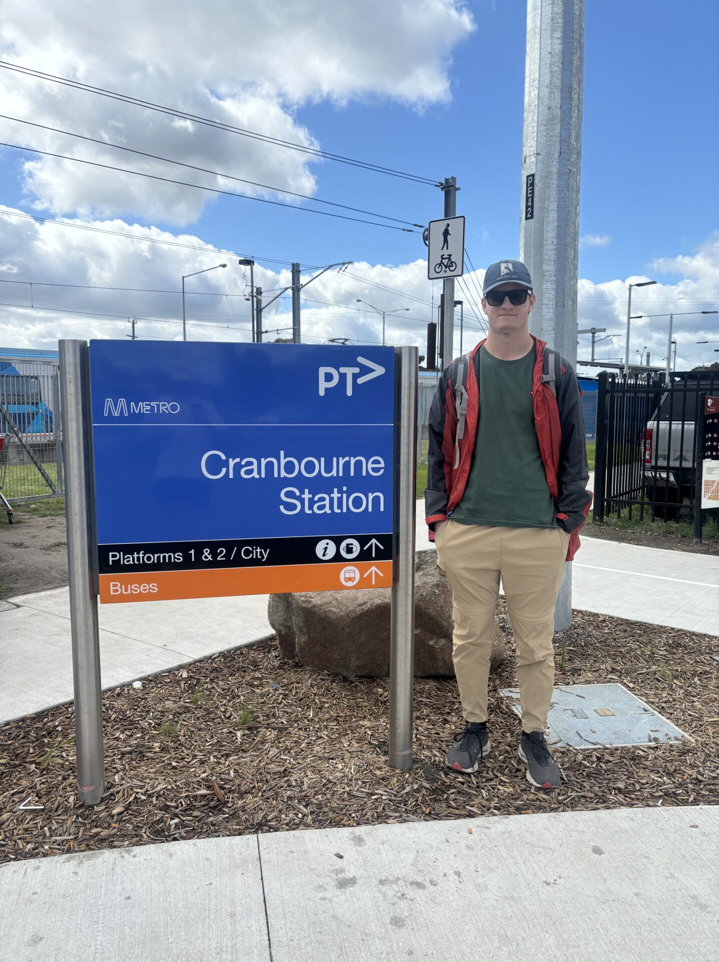 Picture of Daniel standing in front of Cranbourne Station.